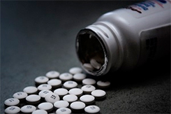 Funding for drug courts and prescription-drug-monitoring programs helps fight the opioid crisis Opioid pills partially poured from prescription bottle