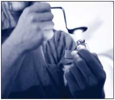 Photo of a person holding a bent spoon containing methamphetamine over a flame, e.g., 'cooking' it.