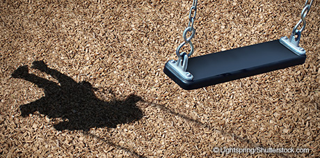 Empty playground swing with shadow of missing child