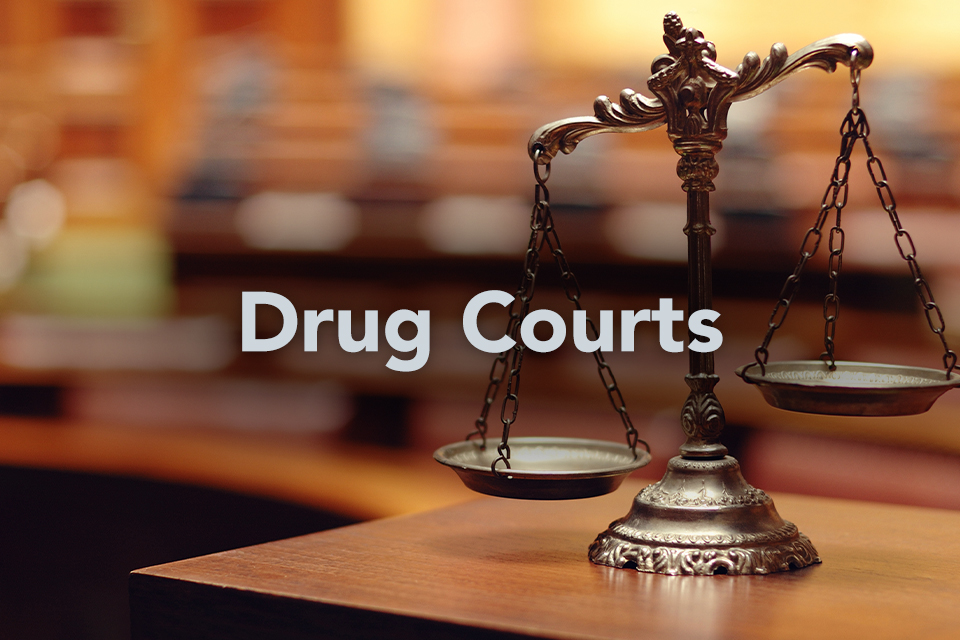 Drug Courts on background of scales of justice