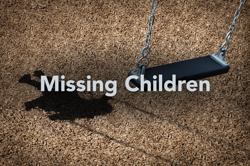 Missing Children text on background of empty playground swing