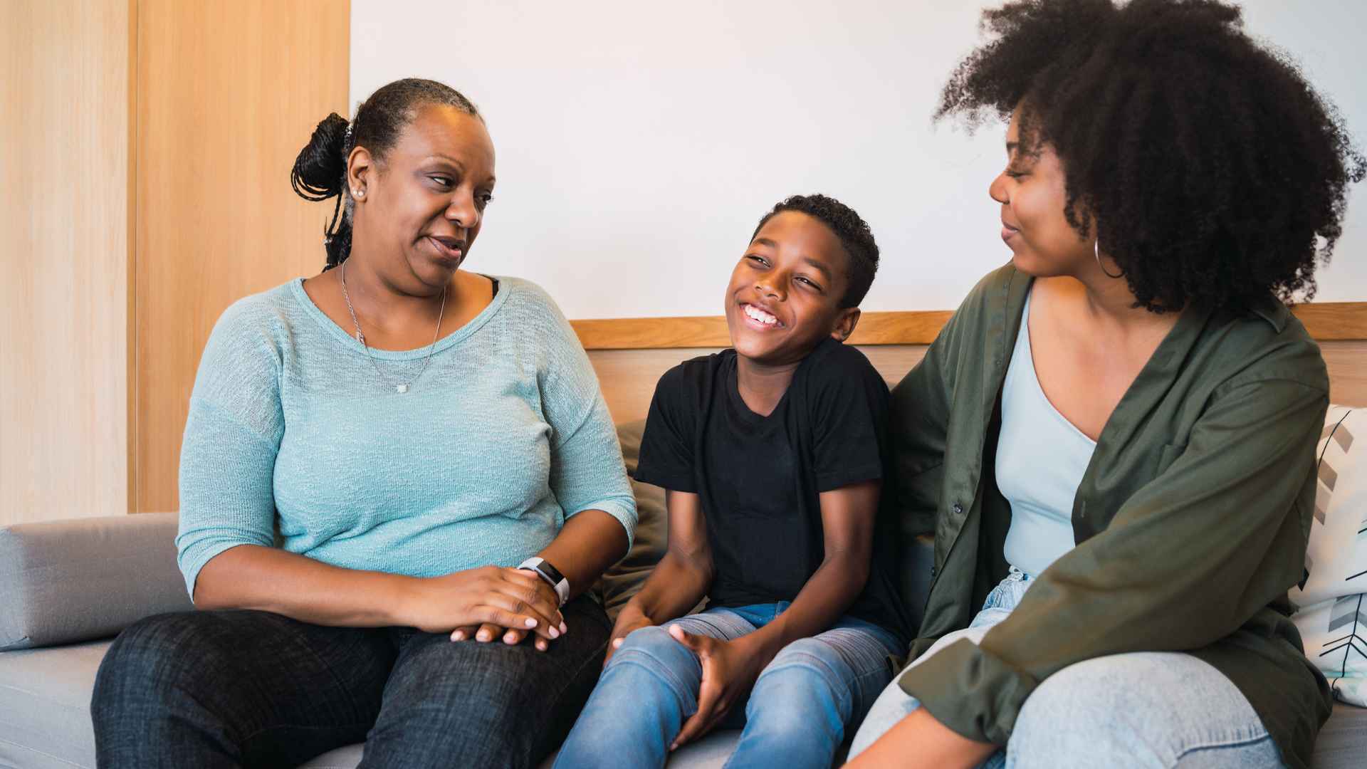 Child sits between two multigenerational women.