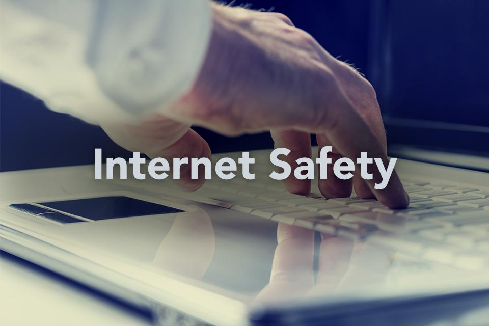 Internet Safety on background of hand typing on computer