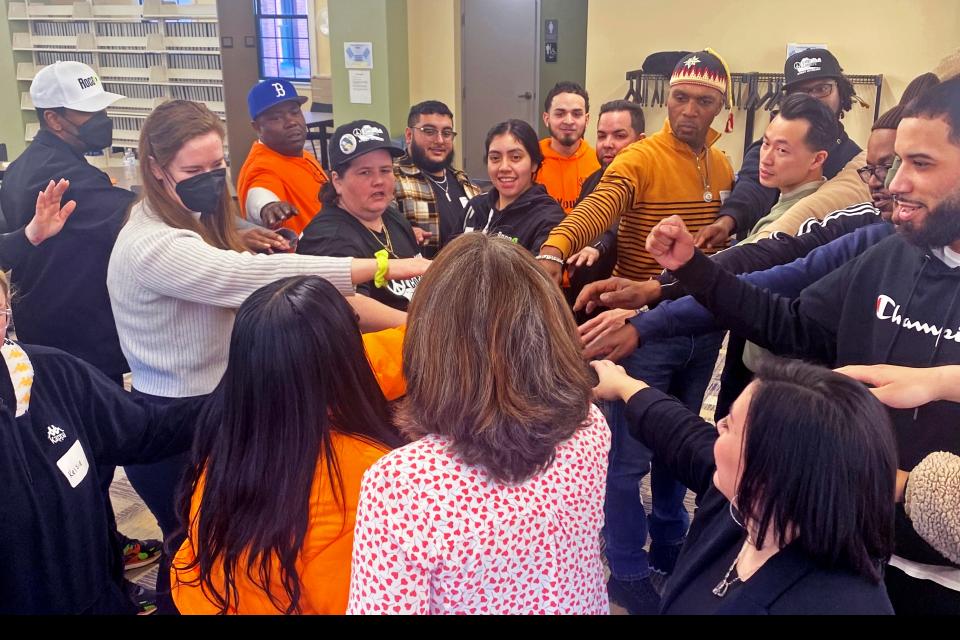 Group of adults in form a circle with hands extended to the middle of circle