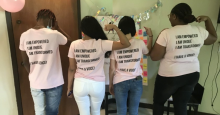Four people with pink t-shirts with their backs facing