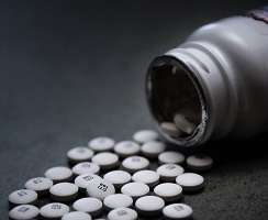 Funding for drug courts and prescription-drug-monitoring programs helps fight the opioid crisis Opioid pills partially poured from prescription bottle